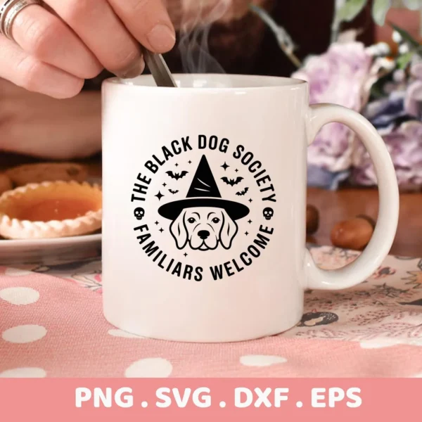 Close-up of a white mug featuring a black vector design of a dog wearing a witch's hat, surrounded by bats and the text "The Black Dog Society, Familiars Welcome," suitable for a Halloween dog shirt design using cutting or serigraphy.