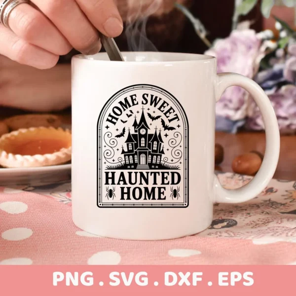 Close-up of a white mug featuring a "Home Sweet Haunted Home" Cricut design with a spooky house graphic, intended for cutting and serigraphy applications.