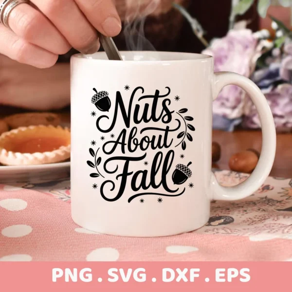 Close-up of a white mug featuring a "Nuts About Fall" design with acorns and decorative flourishes, intended for Cricut cutting and serigraphy applications on autumn-themed apparel or home decor.