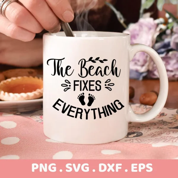 Close-up of a white mug with the text "The Beach Fixes Everything" in black, stylized font, featuring small footprints, part of a digital download bundle including SVG and PNG formats.