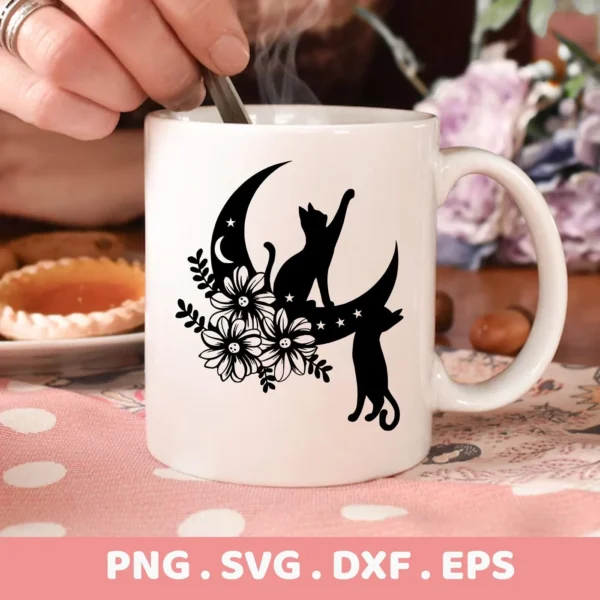 A white mug features a black silhouette design of two cats on a crescent moon adorned with flowers and stars; this is a Floral Cats Moon SVG File digital download bundle (SVG, PNG).