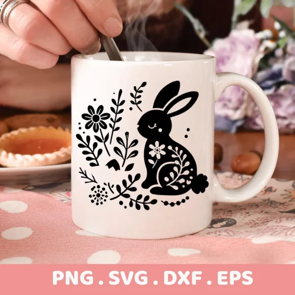 Close-up of a white mug featuring a black floral bunny SVG Cricut design, part of a digital download bundle (SVG, PNG, DXF, EPS).