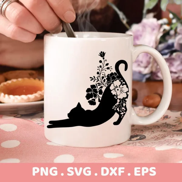 A white mug displays a black floral cat silhouette SVG design of a stretching cat adorned with flowers; a digital download bundle (SVG, PNG).