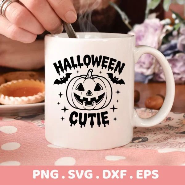 Close-up of a white mug featuring a "Halloween Cutie" Cricut design with a smiling pumpkin, bats, and stars, intended for cutting or serigraphy applications.