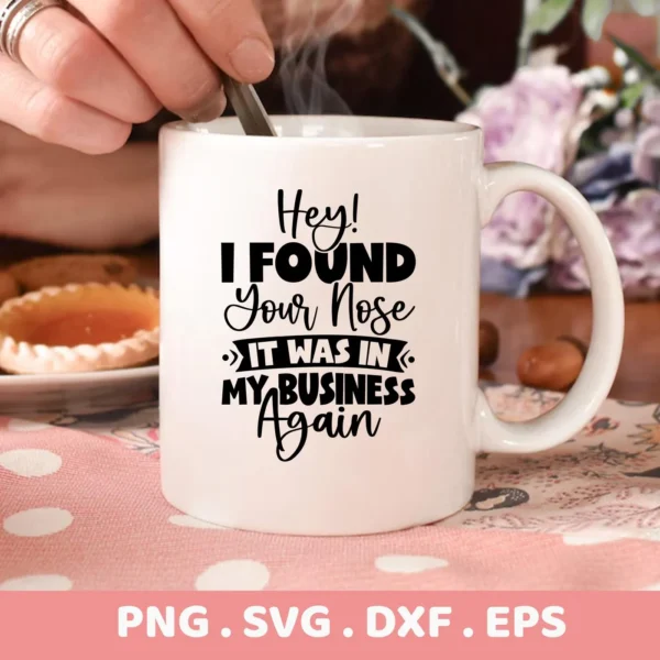 A white mug with the funny quote "Hey! I Found Your Nose, It Was In My Business Again" is displayed, representing a digital download bundle including SVG and PNG files for crafting.