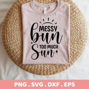 A folded light pink t-shirt with the text "Messy Bun Too Much Sun" in black script, representing a Messy Bun SVG Design available as a digital download bundle (SVG, PNG).