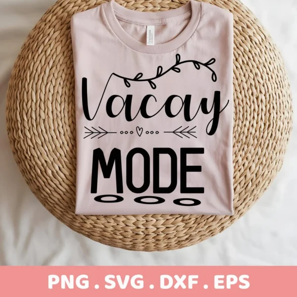 A folded light pink t-shirt with the text "Vacay Mode" in black, featuring decorative elements, rests on a woven surface; this is a Vacay Mode SVG Design available as a digital download bundle including SVG and PNG formats.