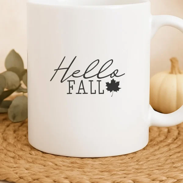 White mug with "Hello Fall" SVG design, a digital download for autumn crafts.