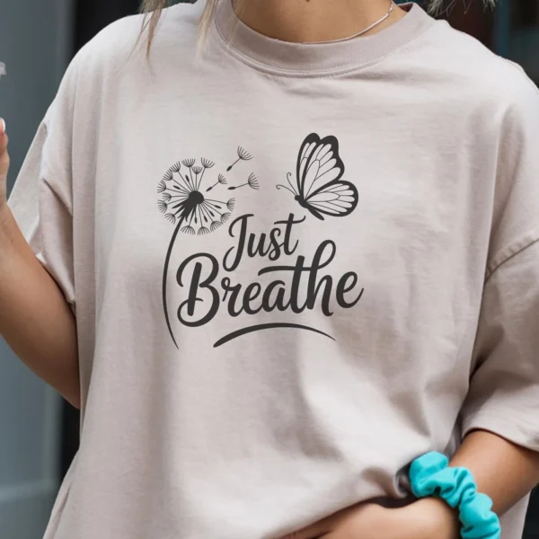 T-shirt featuring a "Just Breathe" SVG design with dandelion and butterfly, a digital file for crafters.